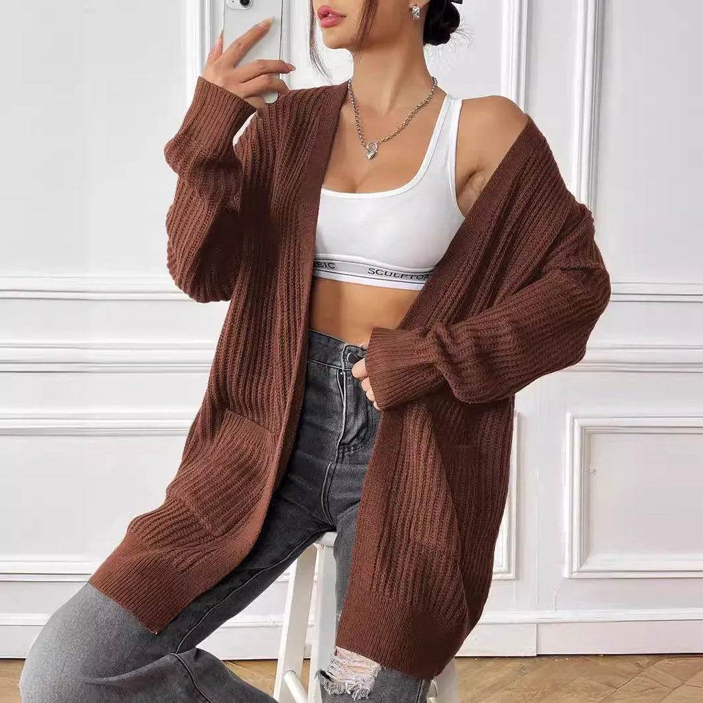 Womans loose fit acrylic cardigan sweater in dark green, showing mid-length and long sleeves.