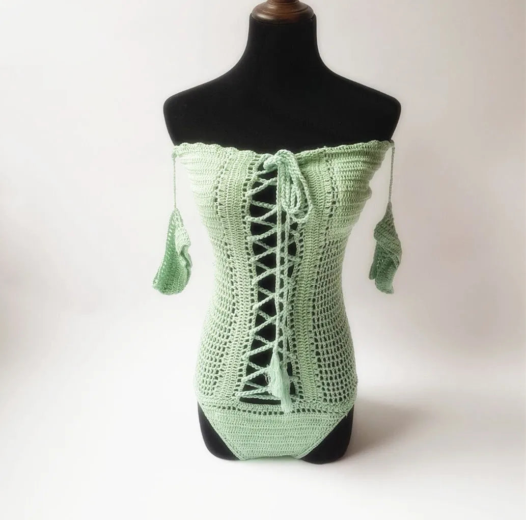 Off-the-shoulder one-piece swimsuit in light pink on a mannequin.