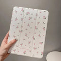 Transparent floral tri-fold iPad case with magnetic stand, showing cartoon print on clear PC hard shell.