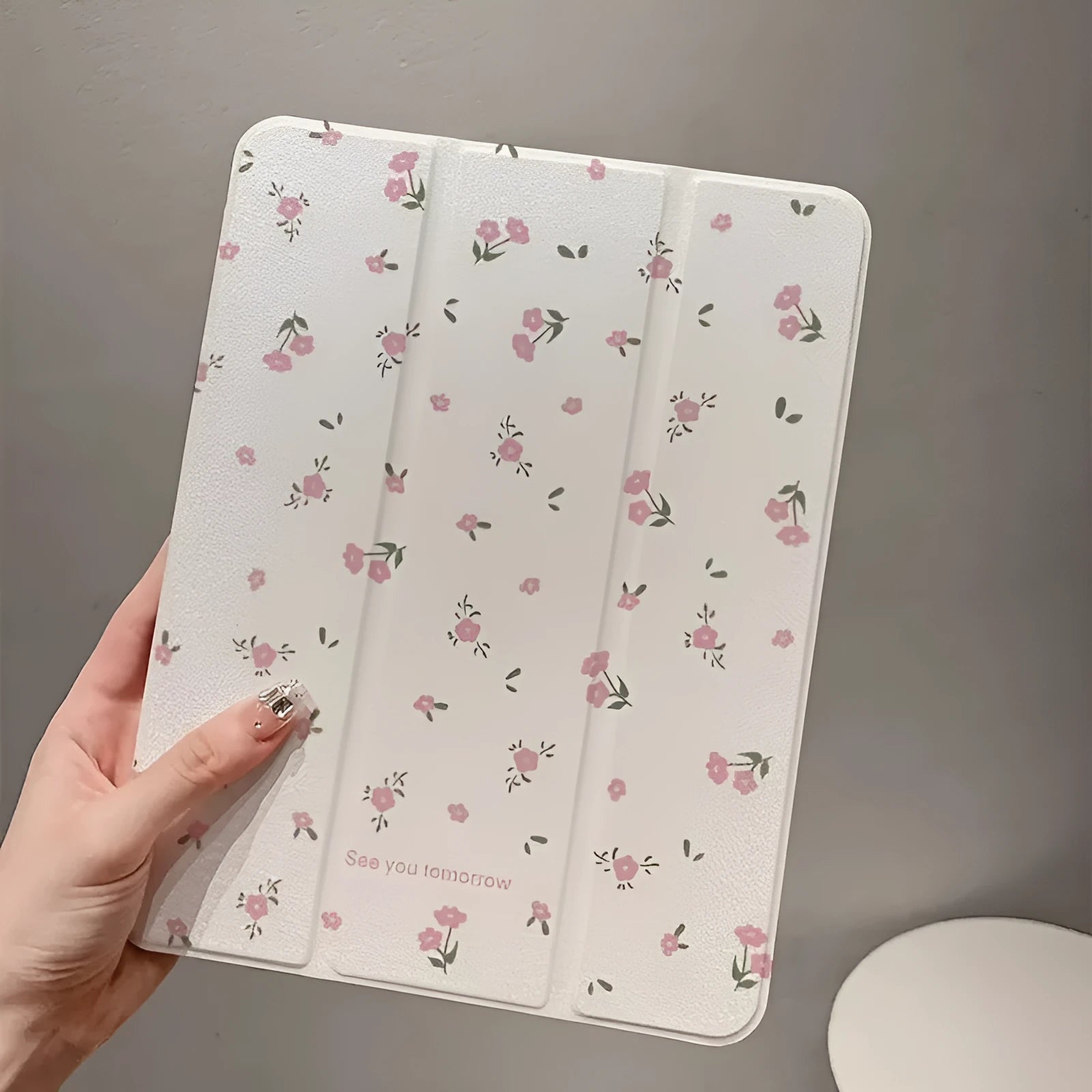 Transparent floral tri-fold iPad case with magnetic stand, showing cartoon print on clear PC hard shell.