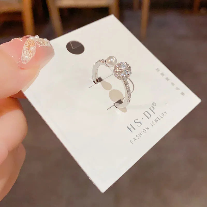 Open-end women's ring with round zircon and pearl elements in gold or silver real gold plating