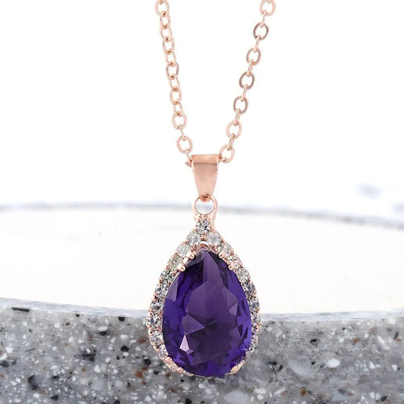 Women's geometric drop shape pendant necklace with rhinestone detail in pink electroplated finish.