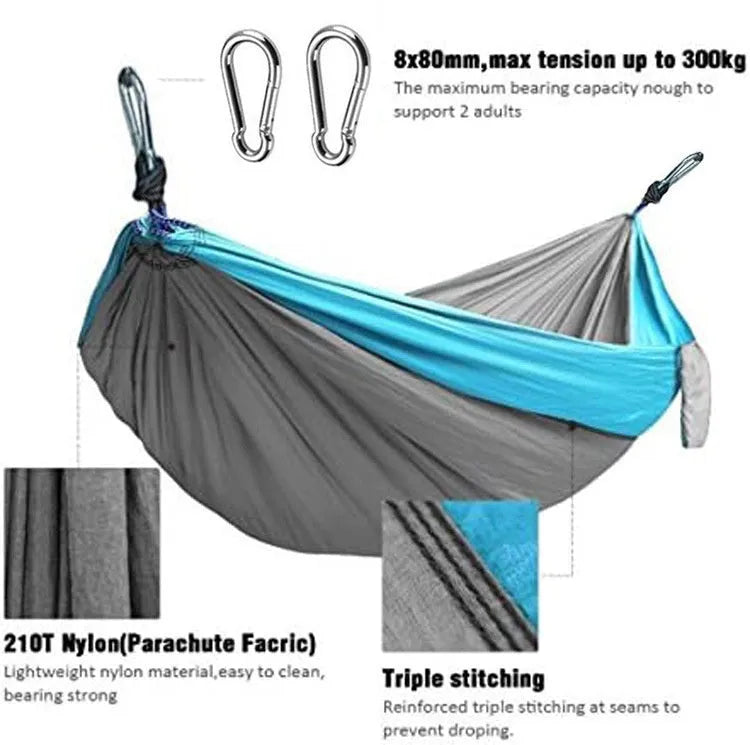 Blue parachute nylon camping hammock hung between two trees showing its full 270 cm length.