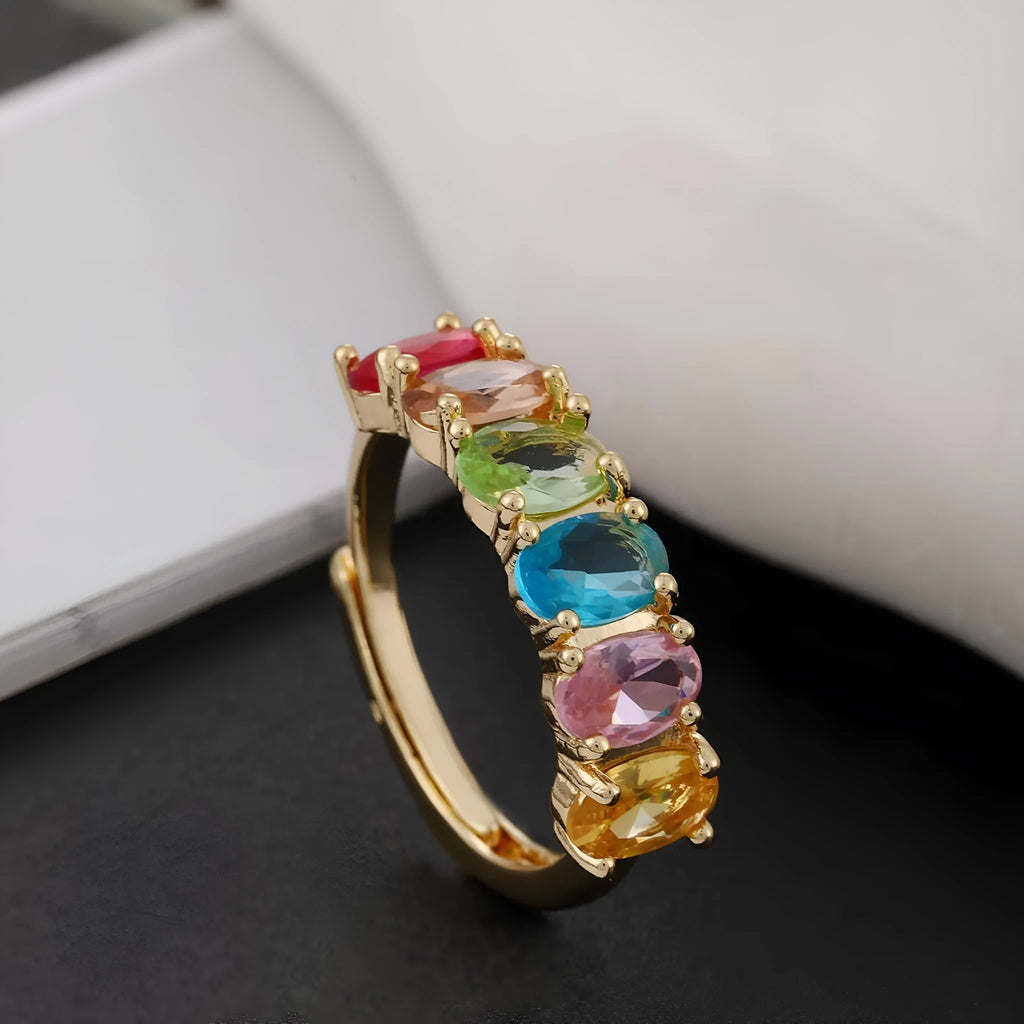 Gold coloured adjustable ring with zircon detail on a white background.