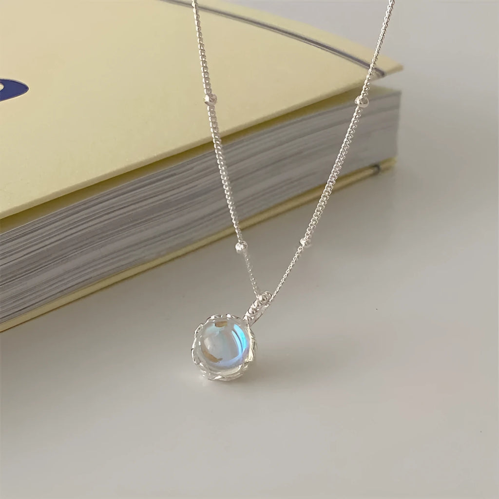 Women's sterling silver necklace with round geometric pendant on an adjustable curb chain.