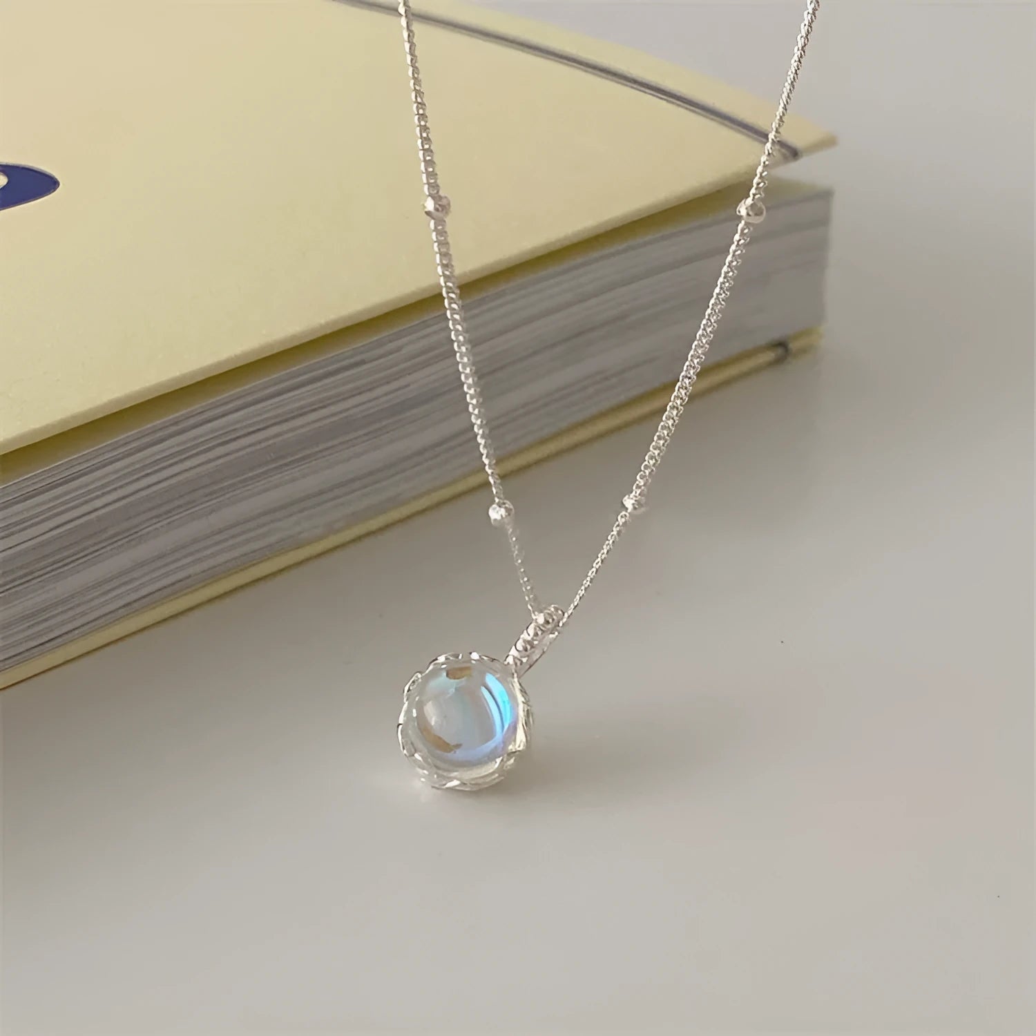 Women's sterling silver necklace with round geometric pendant on an adjustable curb chain.