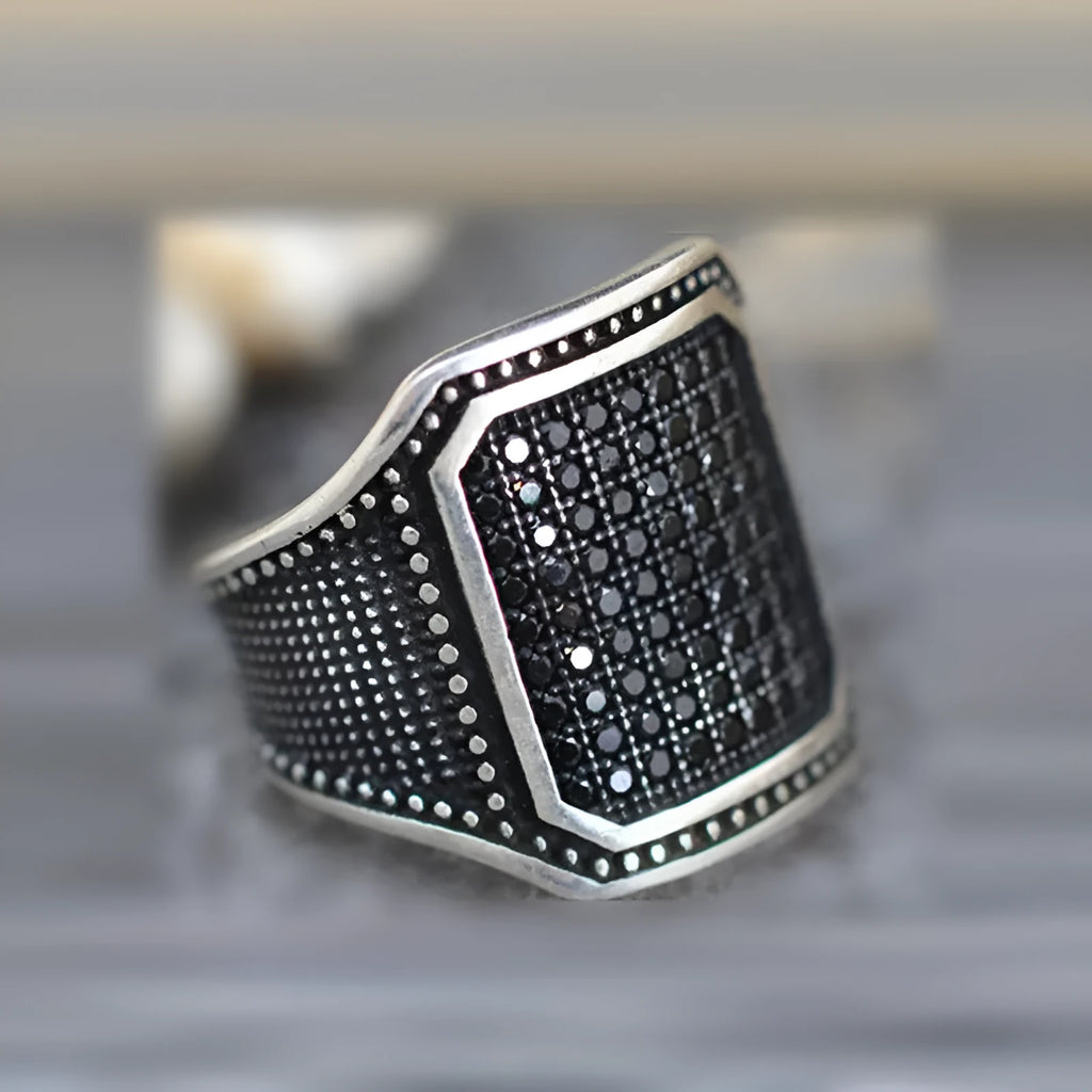 Black alloy ring with copper inlay and zircon stone detail shown in unisex design