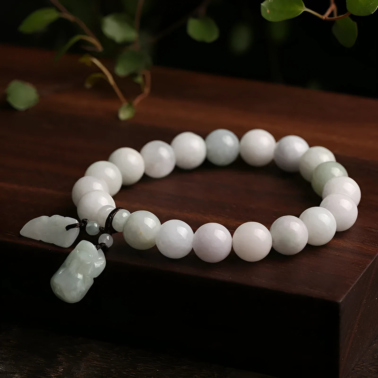 Natural green jade bracelet with a hanging Maitreya Buddha charm on a wrist.