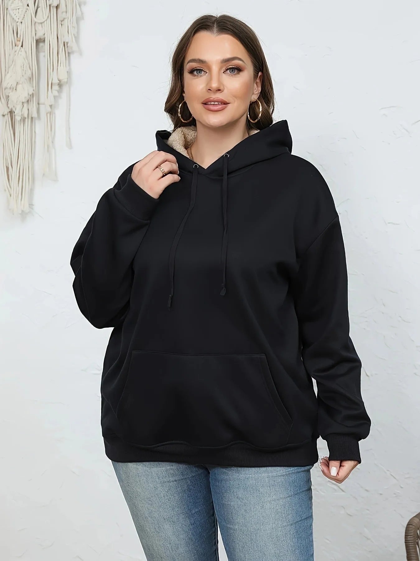 Women's black hooded sweater with a raised 3D pattern, featuring a loose fit and long sleeves.