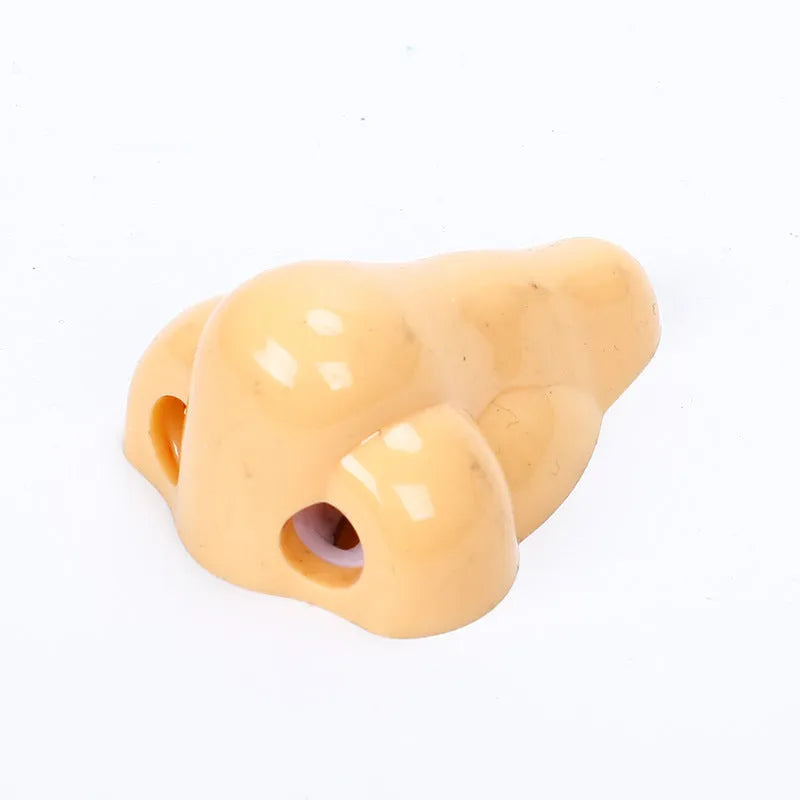 Flesh colour plastic student pencil sharpener with large nostril hole showing geometry shape