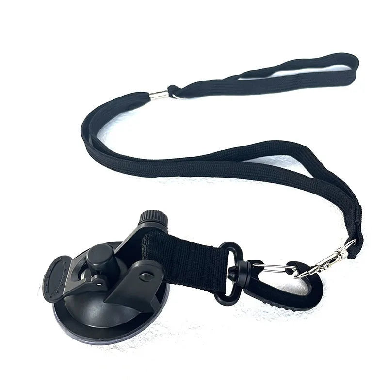 Black pet bathing restraint with four suction cups, a traction rope, and anti-bite handcuffs on a tiled wall.