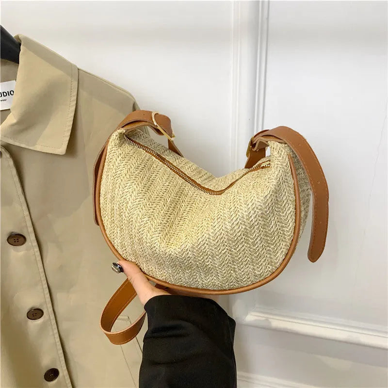 Women's straw woven crossbody bag showing texture and internal phone and file compartments.