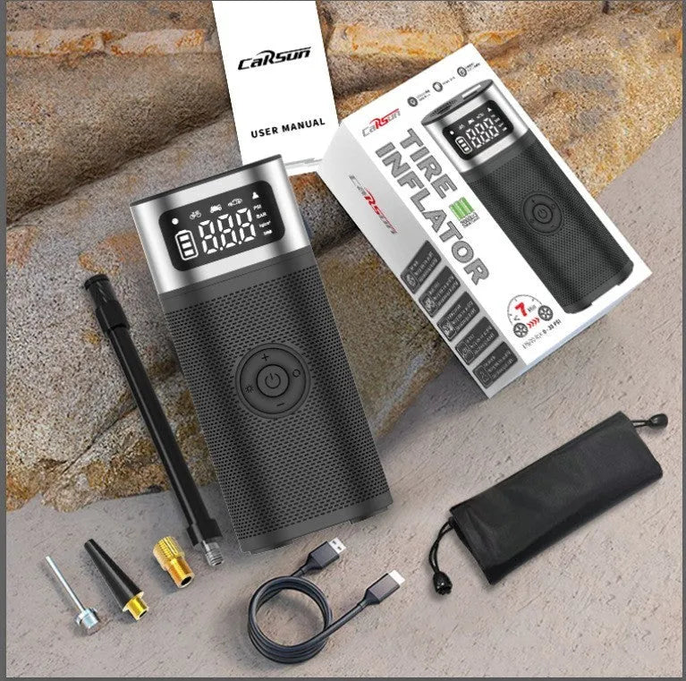 Black portable wireless smart vehicle air pump with a display, inflation tube, and multiple nozzles on a dark background.
