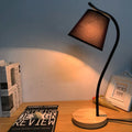 Modern eye protection desk lamp with dimmer switch on a wooden desk, showing black and white style options.