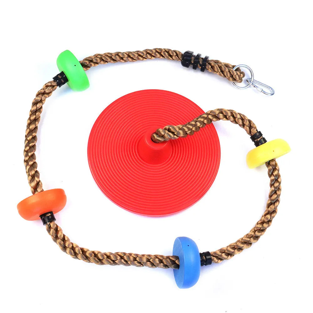 Plastic children's swing set with four colourful platforms on a climbing rope in a backyard
