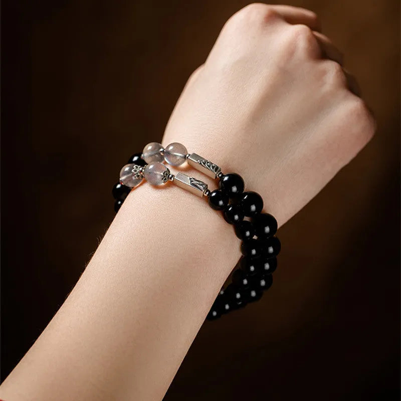 Black obsidian Buddha beads bracelets for couples, showing 8mm and 10mm bead sizes on a traditional cord.