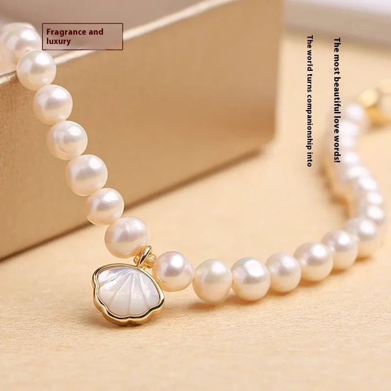 Women's freshwater pearl bracelet with fan-shaped design on wrist, showing elastic and chain fastening options.