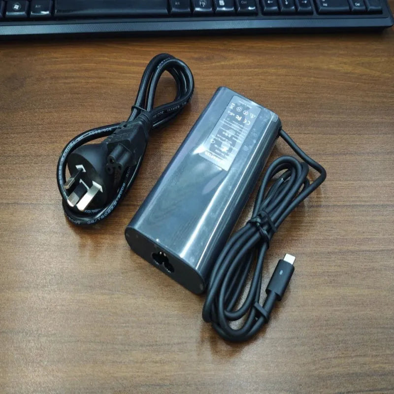Black 65W Type-C laptop power adapter with multiple international plug heads on a white background.