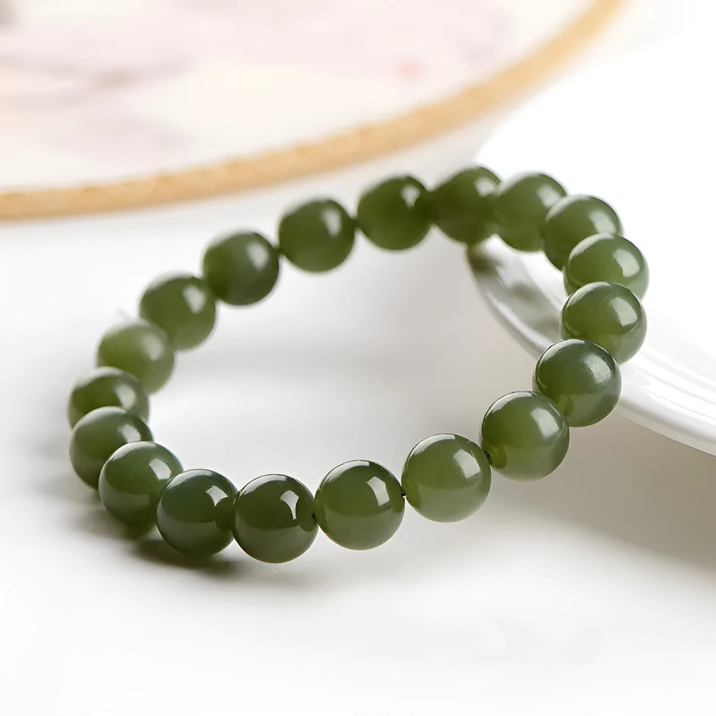 Polished Hetian jade ball bracelet in ice clear colour on a wrist, showing spherical beads.