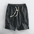Man wearing striped cotton shorts with an elastic waistband in a light grey colour.