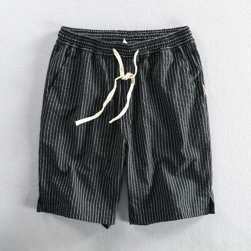 Man wearing striped cotton shorts with an elastic waistband in a light grey colour.