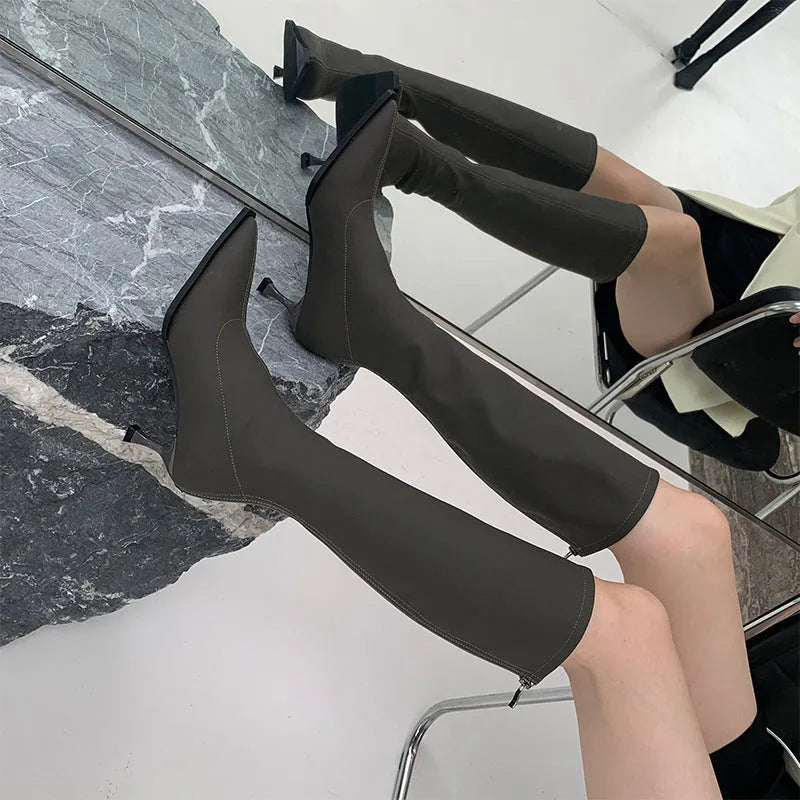 Black women's pointed toe below knee boots with a stiletto heel and a back zip fastener.