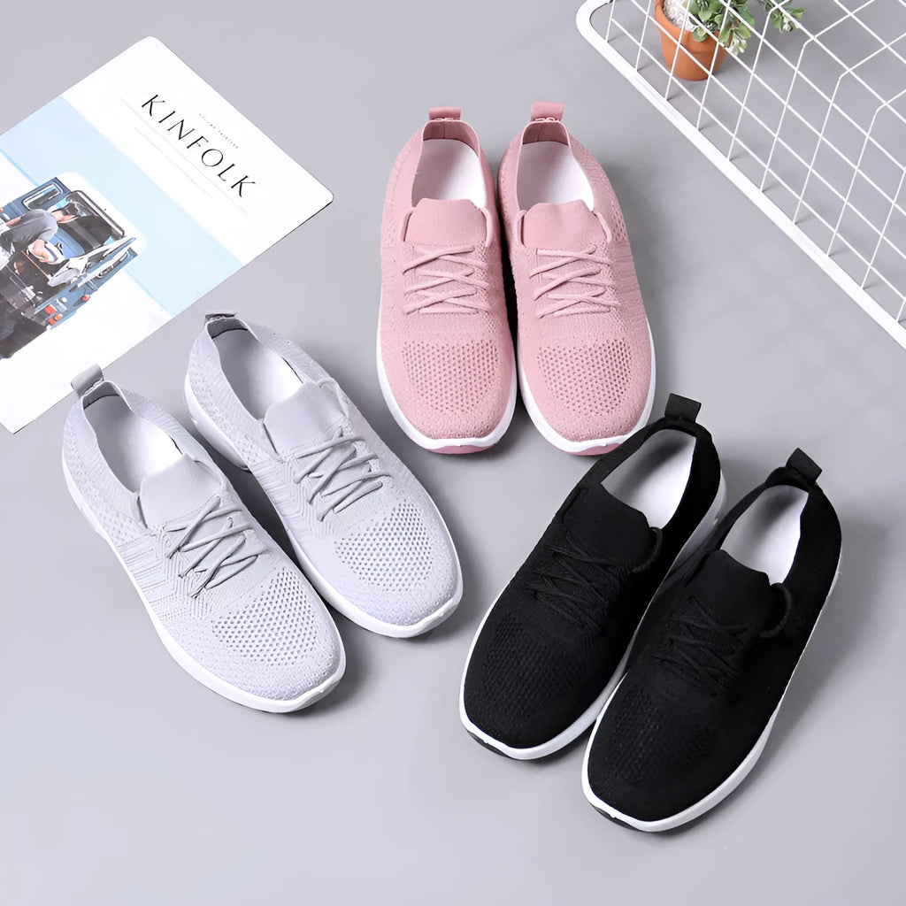 Women's black mesh sneakers with a soft sole and round toe, shown with lace-up front closure.