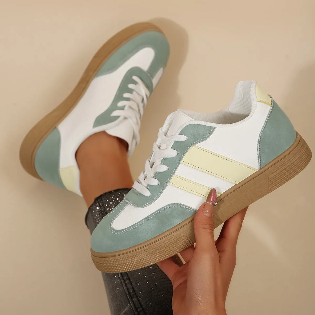 Women's green retro sports shoes with white cross straps, low top, flat rubber sole, and round toe.
