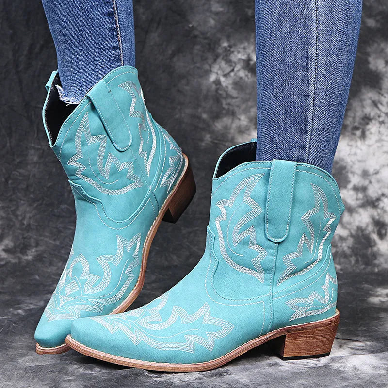 Women's blue cowboy boots with wedge heel, pointed toe, and embroidery details on low canister.