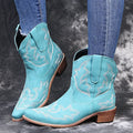 Women's blue cowboy boots with wedge heel, pointed toe, and embroidery details on low canister.