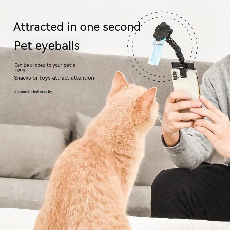 Black pet photography clip with rotating treat holder attached to mobile phone