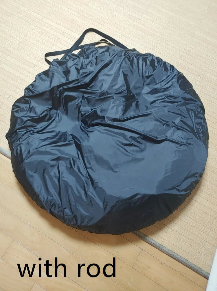 Black pop-up car tailgate camping tent unfolded next to a vehicle