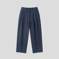 Men's apricot coloured loose-fit cotton linen trousers with a pencil leg and elastic waist on a neutral background.