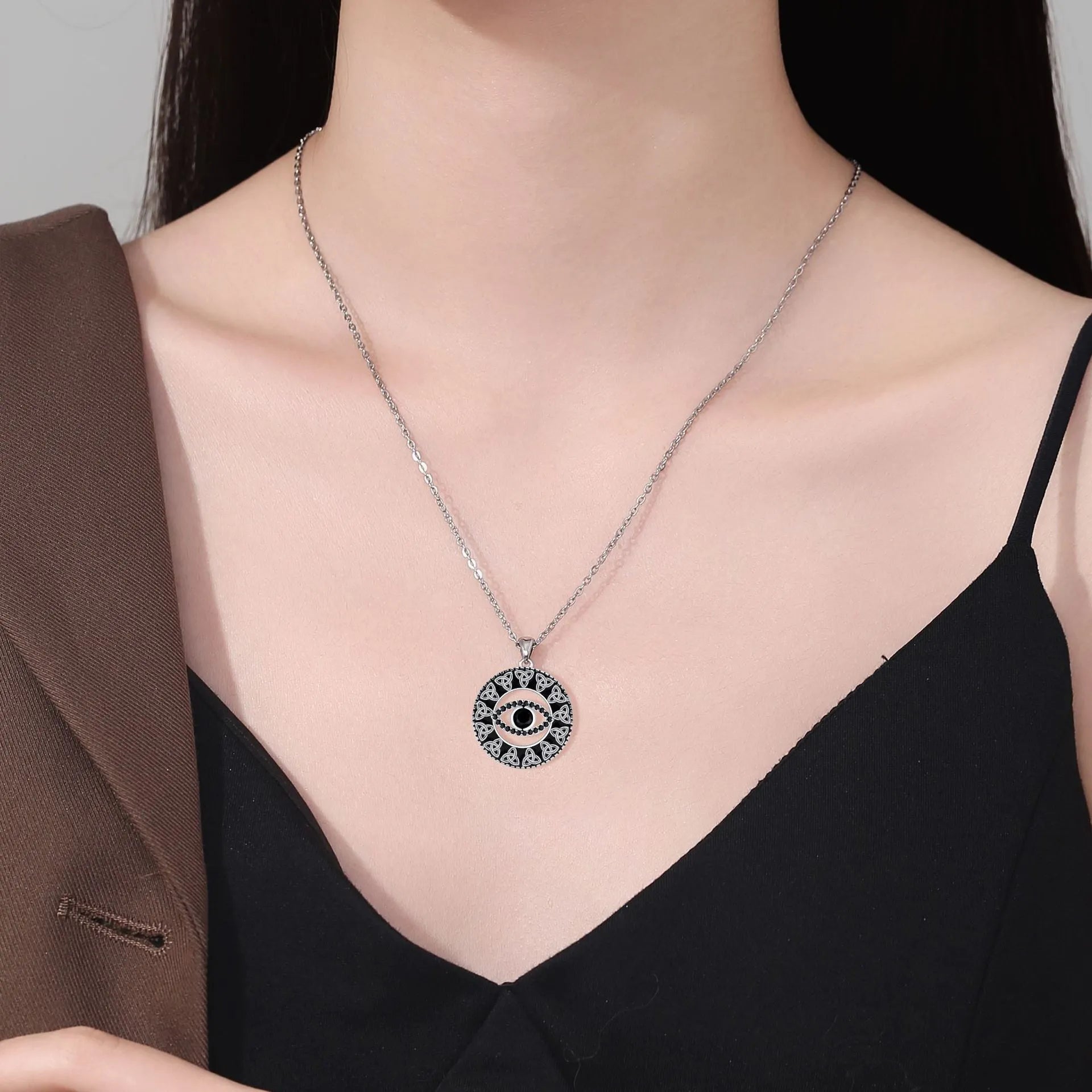 Close-up of a copper Devil's Eye pendant necklace on a cross chain for women.