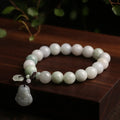 Natural green jade bracelet with a hanging Maitreya Buddha charm on a wrist.