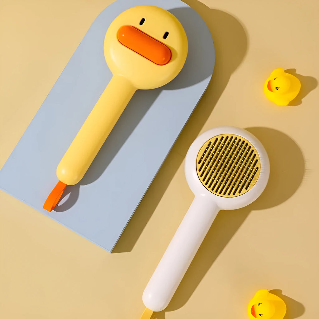 Small yellow duck-shaped pet comb with needle bristles for hair removal on cats and dogs.