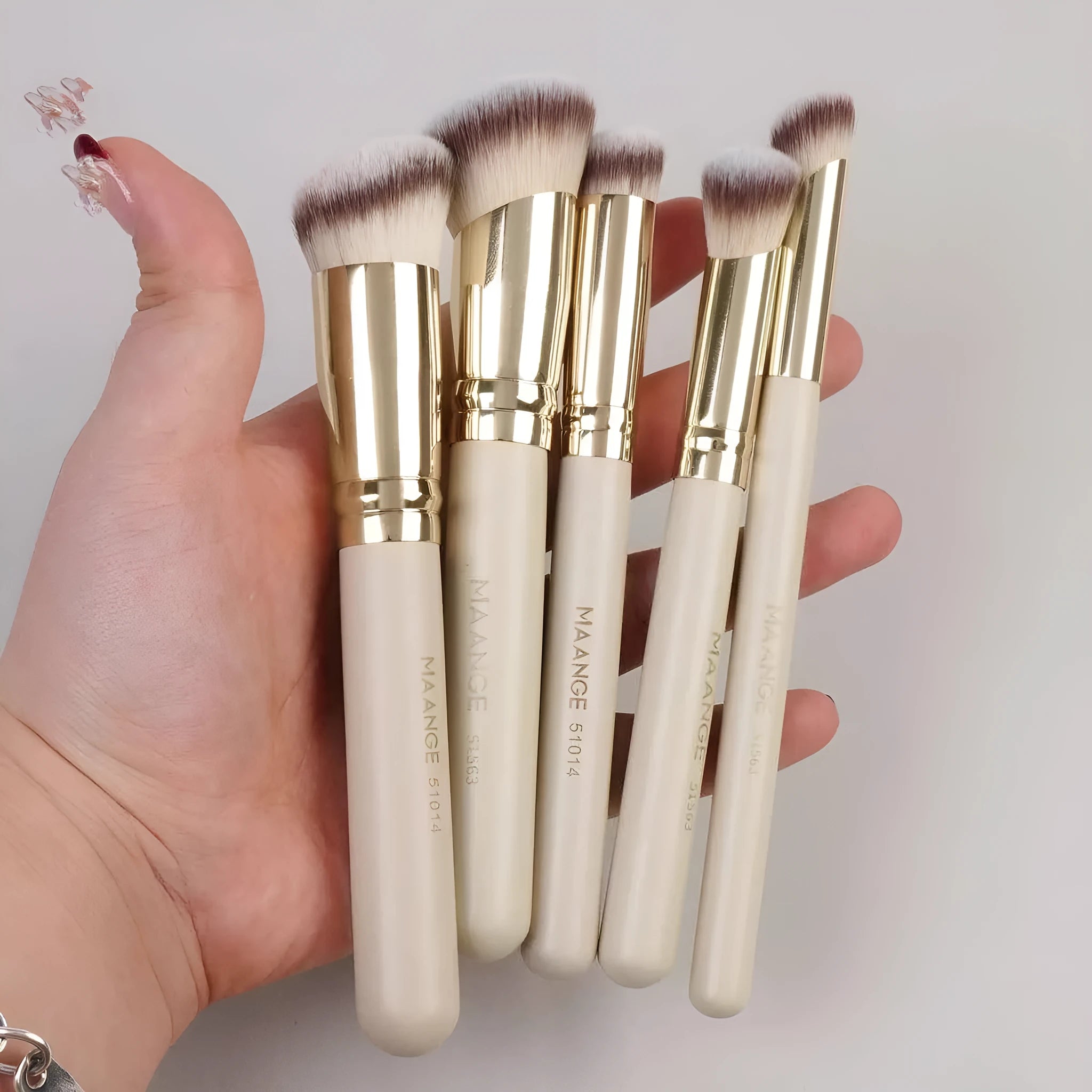Five angled apricot-coloured makeup brushes for powder blush and foundation application