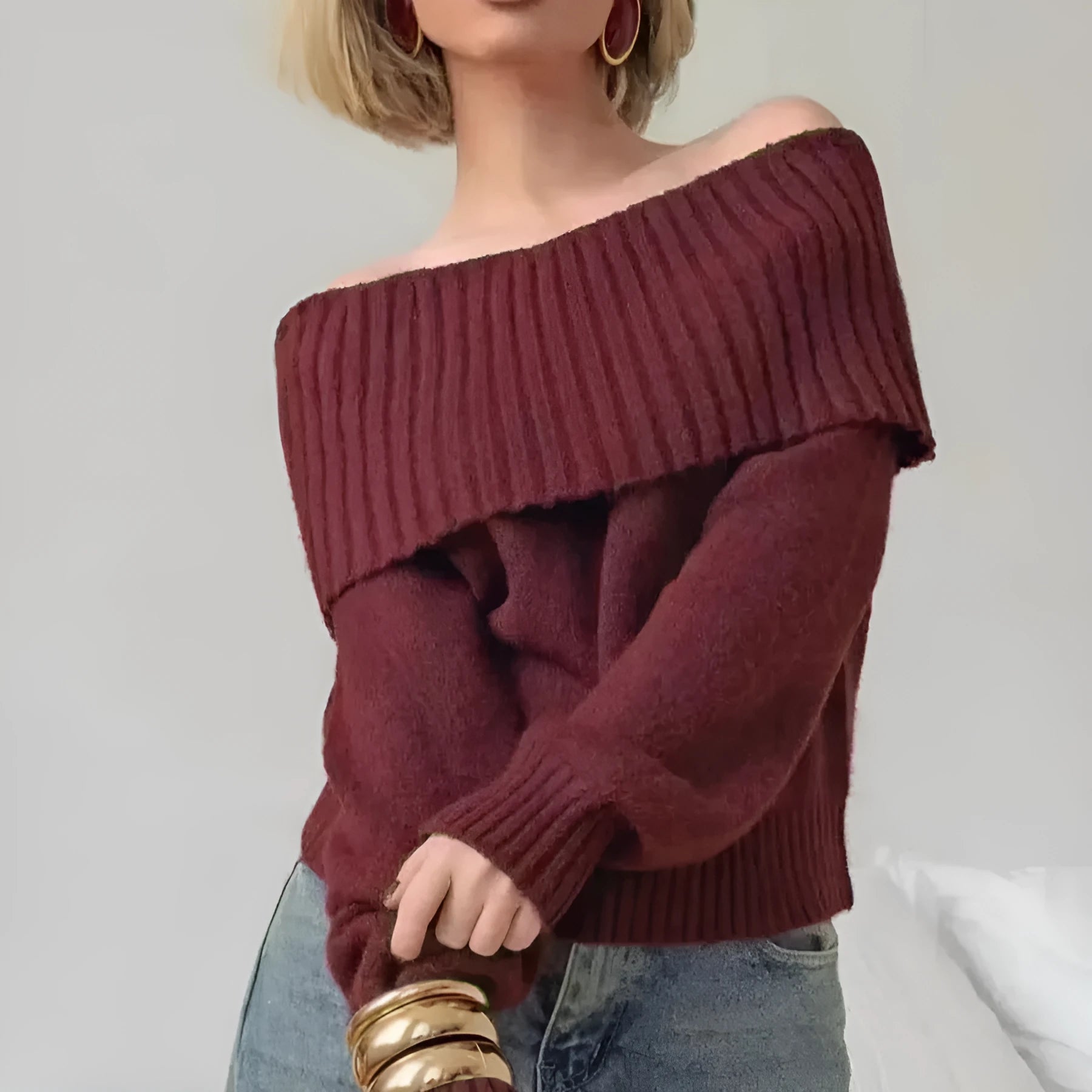 Grey off-the-shoulder sweater with a strapless neckline and a raised 3D pattern across the front.