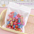 50 small colourful cartoon erasers featuring fruit, animal, cake, and theme designs in a pearlescent bag.