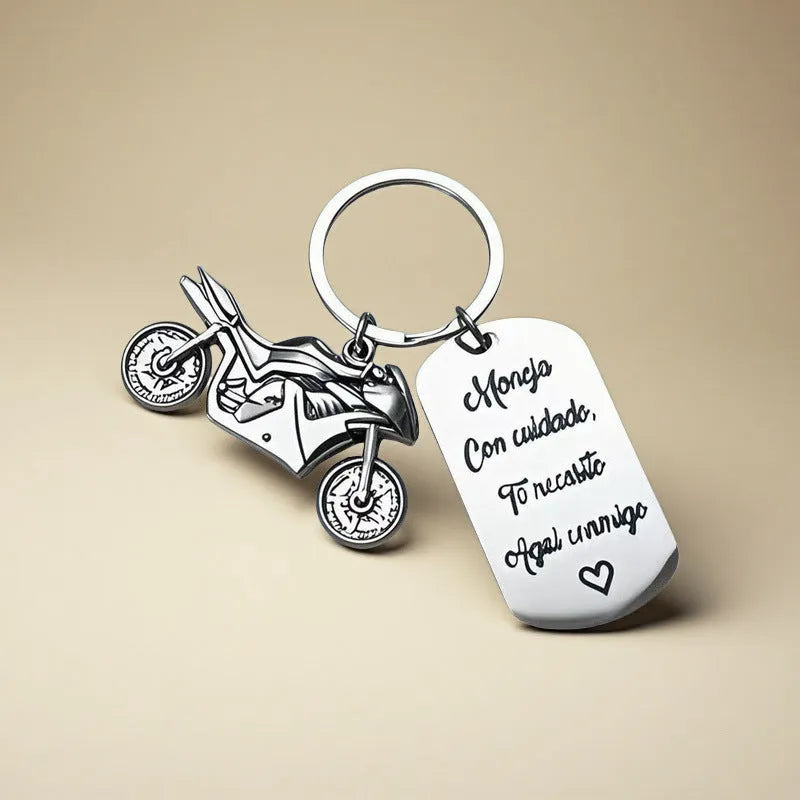 Stainless steel motorcycle keychain with inspirational charm on a flannel bag.