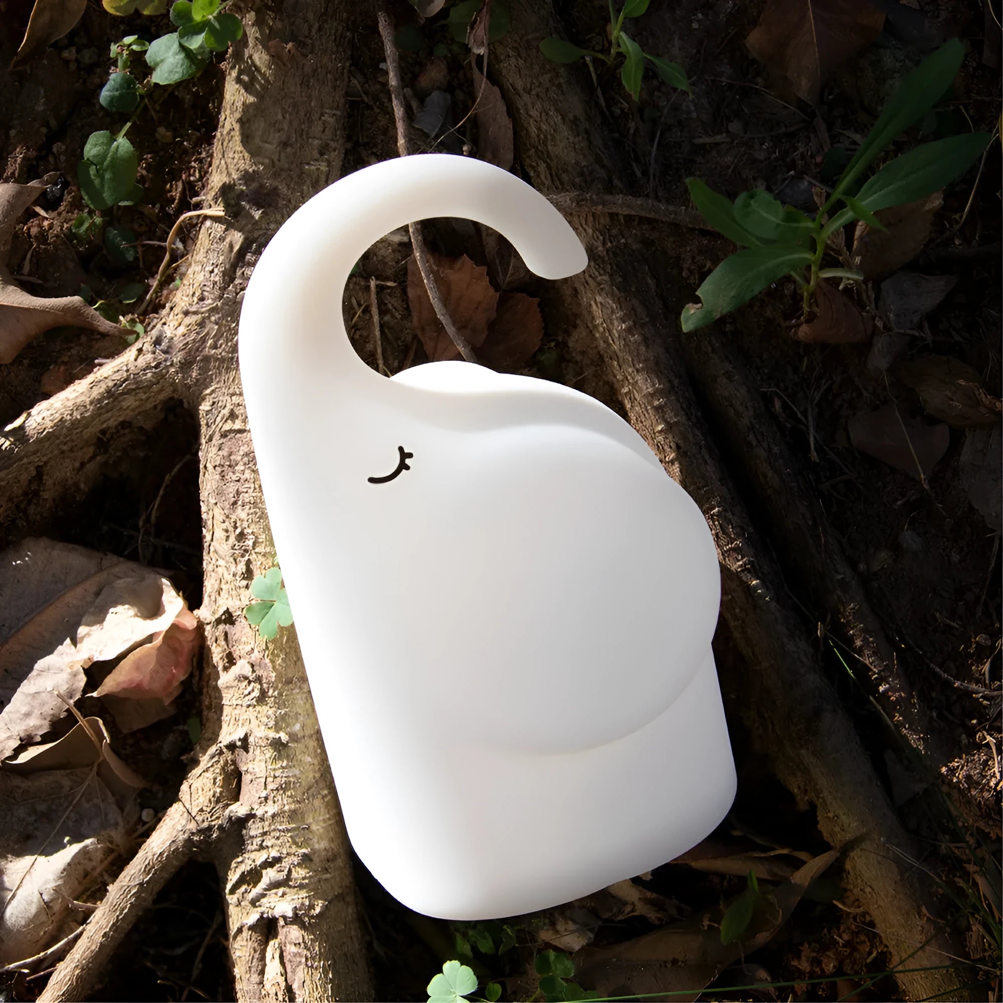 DOMI Elephant-shaped silicone night light with warm white LED glow on a bedside table.