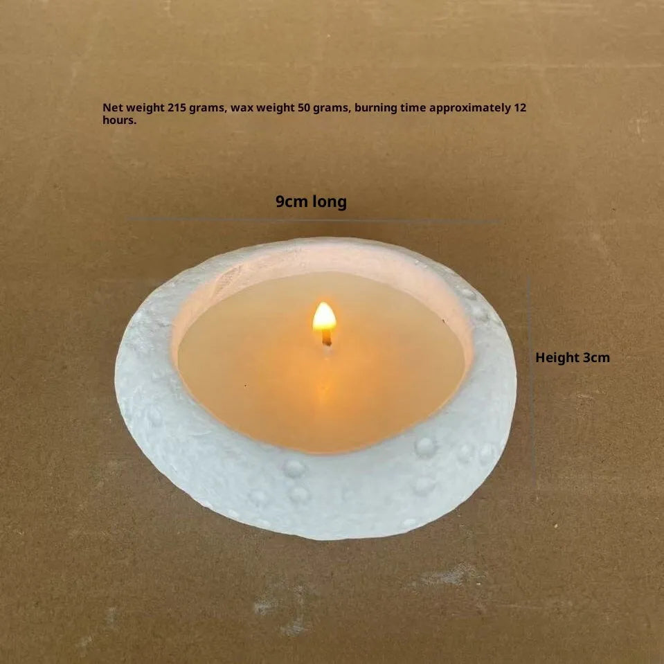 Fair-faced concrete candlestick ornament in white colour on a flat surface