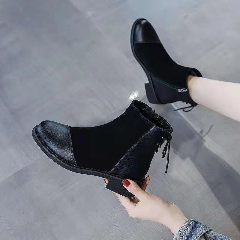Women's black knee-high Martin boots with side zipper, round toe, and short stout heel.