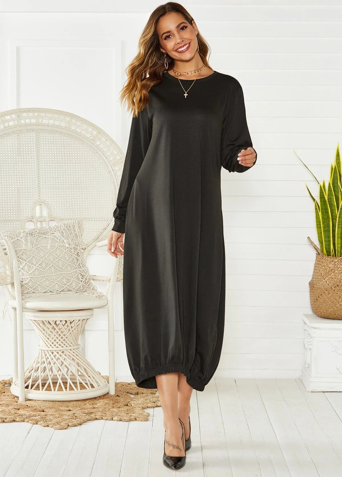 Loose black lantern dress with lace-up crew neck and long sleeves, laid flat.