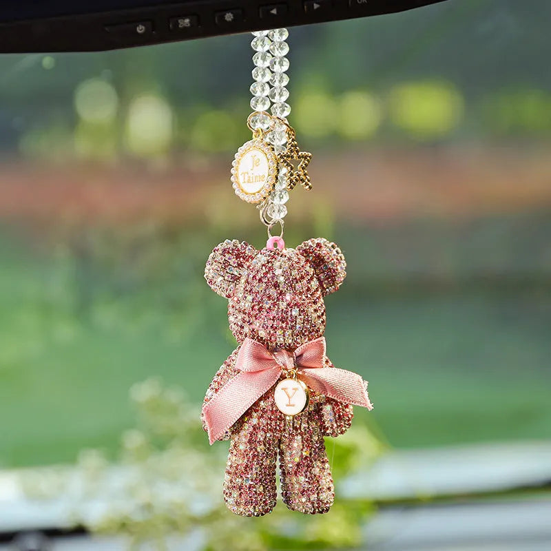 Close-up of a black Violent Bear-shaped car pendant with sparkling rhinestones, hanging from a rearview mirror.