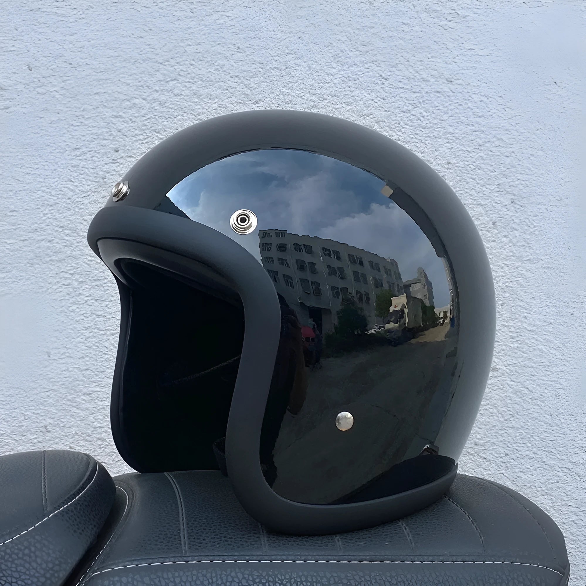 Cement grey retro half motorcycle helmet with glass fibre shell on a plain background.