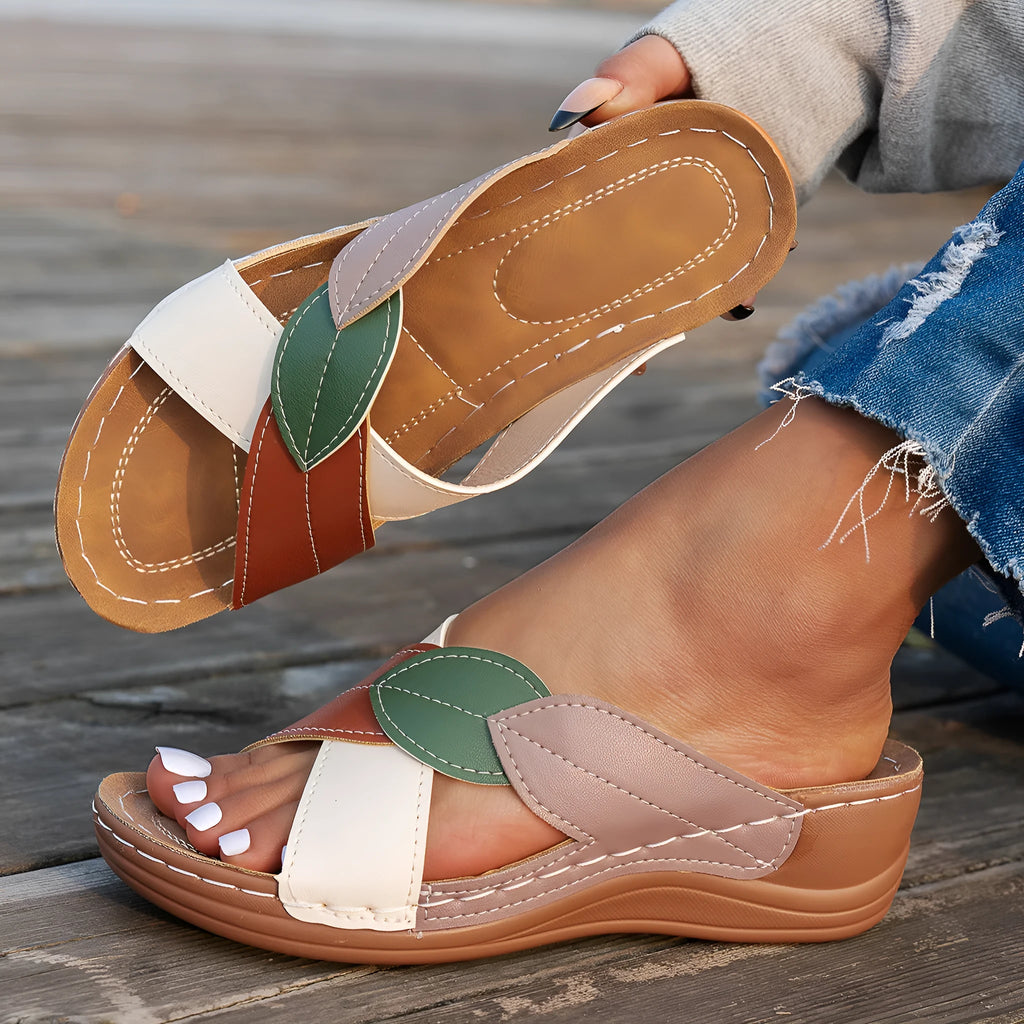 Women's black cross-strap peep-toe slippers with a thick sole, shown from the side.