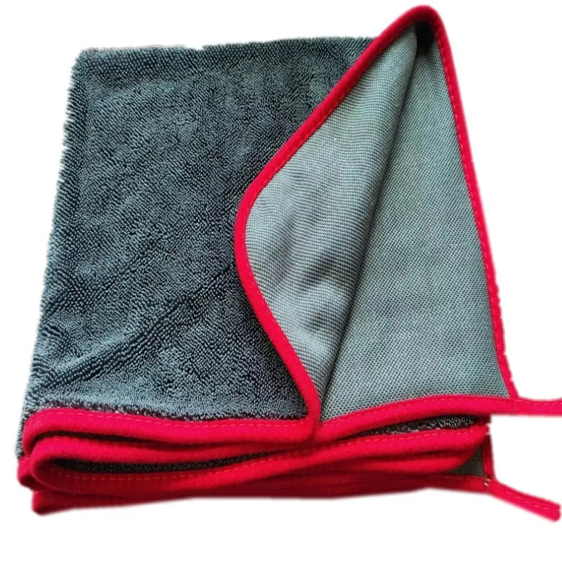 Grey automobile cleaning cloth with black edging showing spiral hair texture and hemmed edges