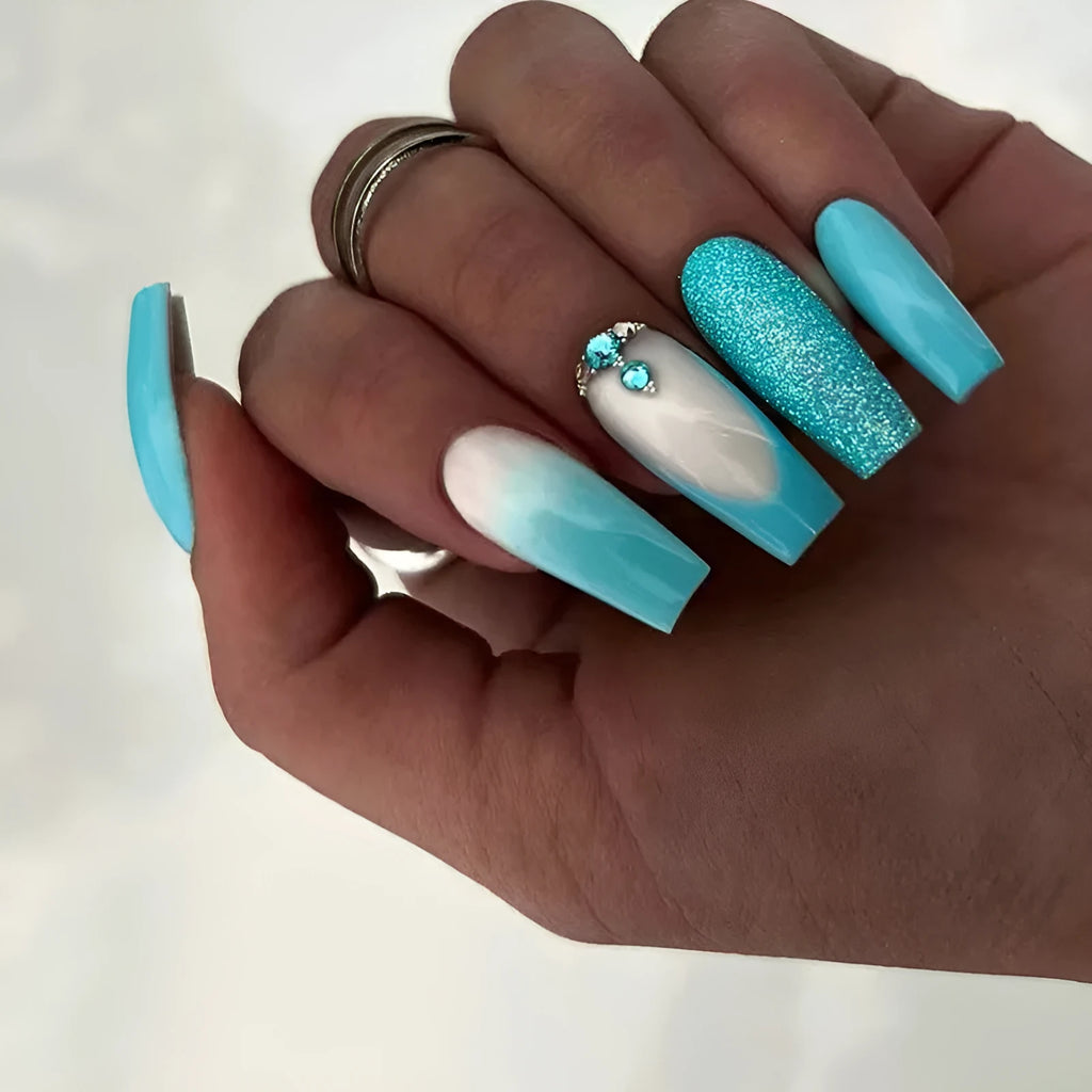 Long ballet false nails with smart blue diamond accents on solid colour background