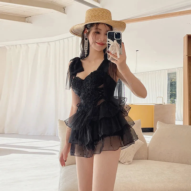 Black conservative one-piece swimsuit with gathered chest detail and high waist